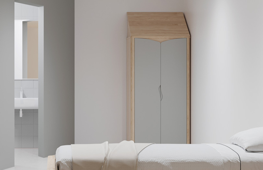 Armoire Acumen en bois clair et portes grises, installée dans une chambre de soins sécurisée avec lit simple.