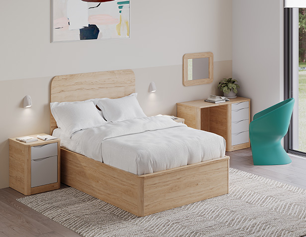 Lit double Acumen en bois clair avec tête de lit assortie, accompagné d’un bureau, d’une table de chevet et d’un miroir mural dans une chambre de soins sécurisée.