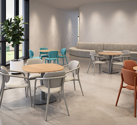 Chaises Appa Dining à structure métallique, disposées autour de tables rondes dans un espace collectif lumineux, conçues pour les environnements de soins et de santé mentale