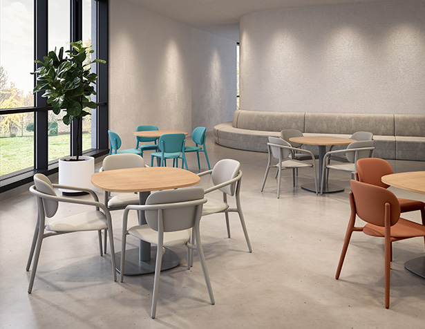Chaises Appa Dining à structure métallique, disposées autour de tables rondes dans un espace collectif lumineux, conçues pour les environnements de soins et de santé mentale